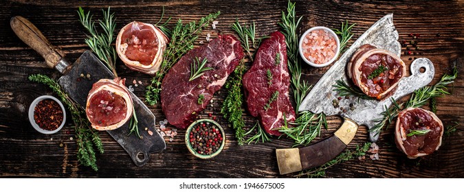 Set Of Various Classic Raw Meat, Veal Beef Steaks Beef Rump Steak, Tenderloin Fillet Mignon Served On Old Meat Butcher On Dark Wooden Background. Banner, Menu Recipe Top View.