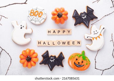 Set of various gingerbread cookies and Happy Halloween wooden blocks on white background. Bright homemade cookies for Halloween party