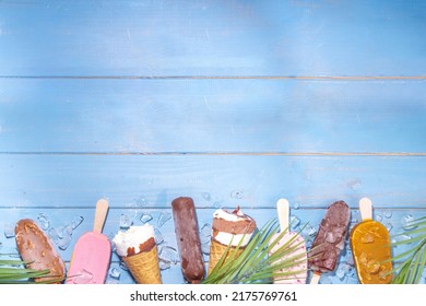 Set of various ice cream popsicle on black background. Assortment of icecream cones and popsicles on wooden blue beach background with tropical palm leaves top view flatlay copy space