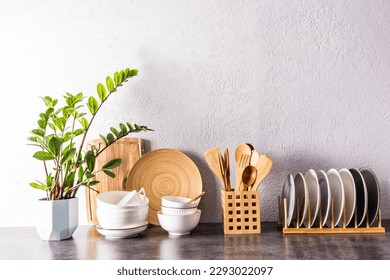 a set of various kitchen utensils and tools, ceramic dishes in light colors on a modern kitchen countertop. front view. a copy space