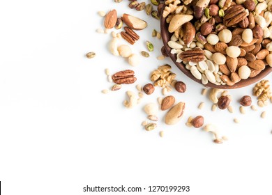 set of various nuts in wooden plates on white background with copy space
