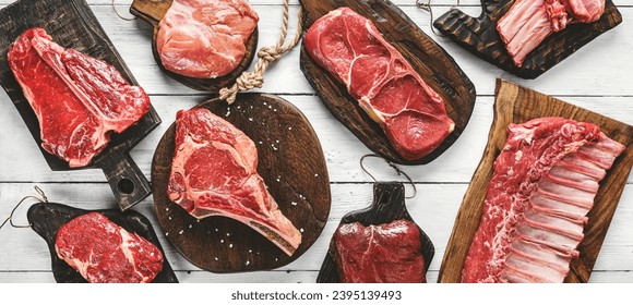 Set of various raw meat steaks. Fresh meat of beef, pork, veal, chicken, steak t-bone, rib eye, tomahawk, ribs, tenderloin on cutting board over white background. Meat food, butcher shop, top view - Powered by Shutterstock