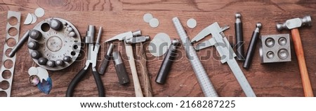 set of various tools placed on a wooden desk in a workshop banner