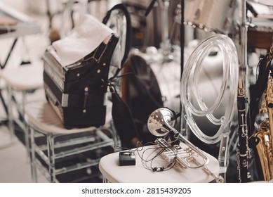 Set in a vibrant music venue, an array of instruments like a trombone, saxophone, and accordion lie ready for a captivating live performance. The atmosphere is filled with anticipation.