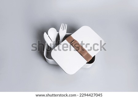 A set of white cutlery made of plastic and paper on the gray background. Eco, environmental conservation concept. Isolated reusable tableware. High quality photo
