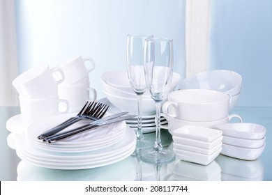 Set Of White Dishes On Table On Light Background