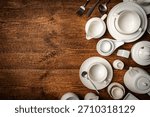 Set of white empty dishes or tableware on wooden background, top view