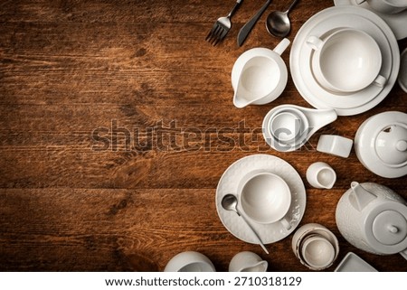Set of white empty dishes or tableware on wooden background, top view