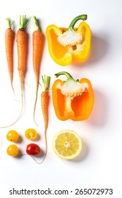 Set Of Whole And Sliced Red, Orange And Yellow Vegetables Over White Background. Top View