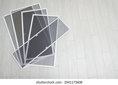 Set of window screens on wooden floor, flat lay. Space for text