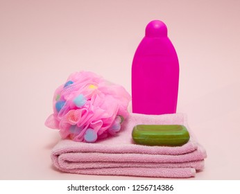 Set Of Woman Aroma Therapy Shower Preparing Equipment Like Towel, Puffy Sponge, Green Fruit Aroma Soap And Shampoo On Pink Background