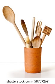 A Set Of Wooden Cooking Utensils In A Terracotta Container Against A White Background