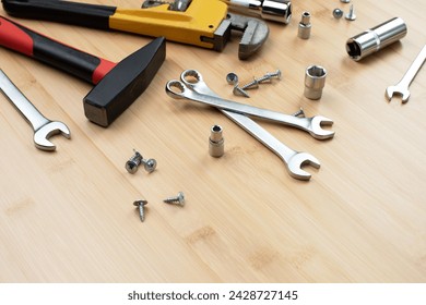 A set of working tools, a hammer, a screwdriver, adjustable spanner, sockets for repair on a bamboo, wooden background. Flat lay