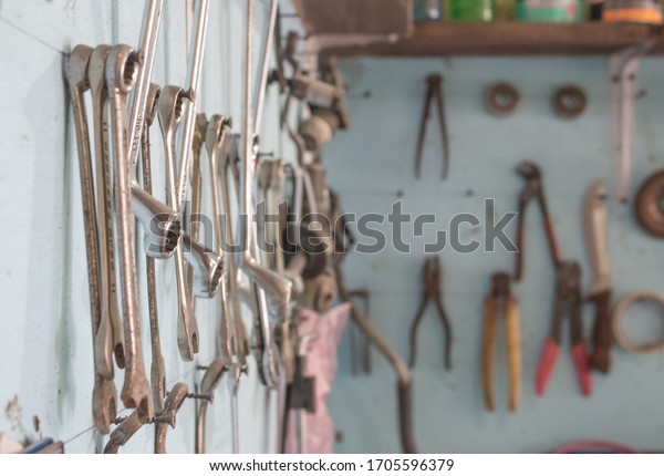 Set of wrenches from the big\
size to the small size hang on a blue wall, garage mechanic\
tool