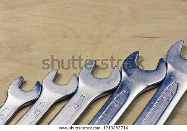 Set of wrenches and spanners keys lie in a row. A\
set of metric spanners or wrenches, open at one end, box or ring at\
the other. Close up macro. Copy space for text. High quality\
photo