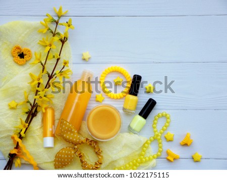 Set of  yellow accessories for young girl or teenager. Nail polishes, lipstick, hair clips, bands, beads, bracelet, perfume and flowers. Spring beauty still life. Copy space. Top view