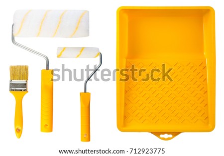 Set of yellow paint tray with paint rollers and brush on light background