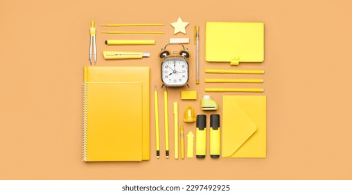 Set yellow school supplies and alarm clock brown background