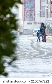 Setif, Algeria - February 28, 2022: Low Angle View Of A Father With His Children Under Snow. Family Having Fun On The Snow Day.