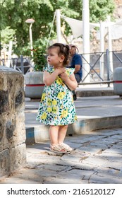 Setif, Algeria - June 4, 2022: Low Angle View Of A Little Cute Arab Girl Standing Outdoor In The City.