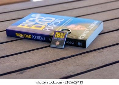 Setif, Algeria - June 9, 2021: Close Up Robert Kiyosaki And Sharon Lechter's Rich Dad Poor Dad Book And Book Keychain. Entrepreneurship Concept.