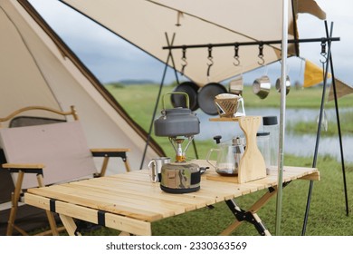 sets of camping equipment in the form of tents and camping tables as well as equipment for making portable coffee in the open and in sunny weather - Powered by Shutterstock