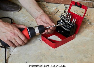 sets the Drill bit in the drill,hands take the drill bit and install in the electric drill