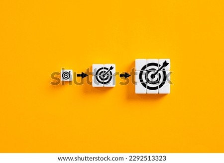 Setting business goals. Developing goals and objectives. Growing target symbols on white cubes on yellow background.