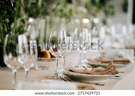 Setting up a dining table with glasses, plates, and napkins for a special occasion in a garden
