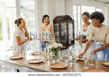 Setting elegant dining table with glassware and flowers, women preparing celebration. elegance, decor, preparation, floral, banquet