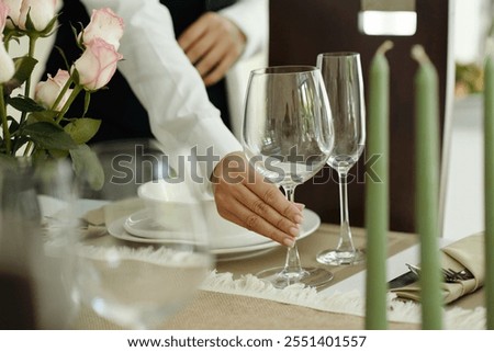 Setting Elegant Dinner Table With Wine Glasses