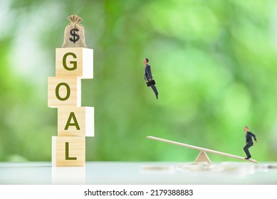 Setting goals and objectives and putting forth great effort to achieve them, business concept : Businessman leaps higher into the air, aided by his partner, who steps on a seesaw to propel him higher.