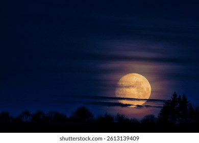 The setting moon hidden behind the clouds