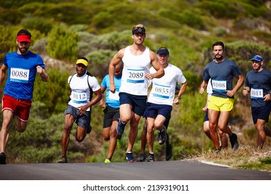 Setting the pace. Shot of a group of young men running a marathon.