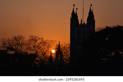 setting sun behind a cathedral while a bird sitting and waiting to return home