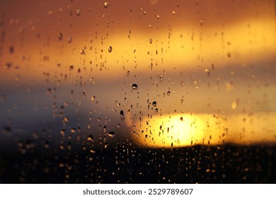 Setting sun behind glass with water drops. - Powered by Shutterstock