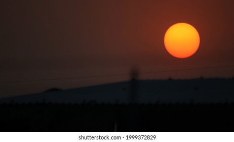 The setting sun behind the mountains.