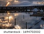 The Setting Sun Blasts through Thick Clouds and Casts a Strong Shaft of Light Down onto Interstate Highway 5, the Ebey Slough, and Surrounding Boat Docks and Ramps near Everett, Washington