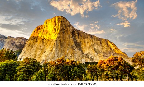 Setting Sun casting glowing sunlight over the famous El Capitan granite rock in Yosemite National Park, California, USA