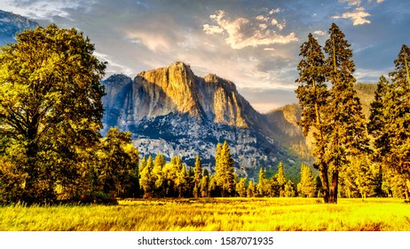 Setting Sun casting glowing sunlight over the almost dry Yosemite Upper Falls at Yosemite Point, the southern shoulder of the Half Dome granite rock in Yosemite National Park, California, USA