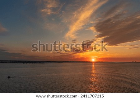The setting sun and evening clouds over the River Humber near Paull, East Riding of Yorkshire, England, UK