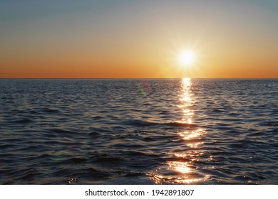 The setting sun goes into the sea on the horizon with a light track and reflections on the sea. Free space - Powered by Shutterstock
