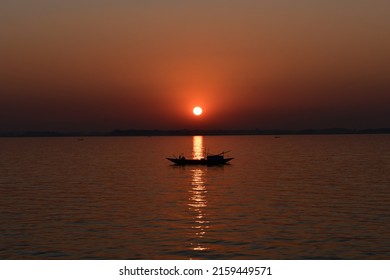 Setting sun makes a graceful view with dingy boat on Meghna river - Shutterstock ID 2159449571