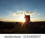 setting sun with rays through a windmill 
