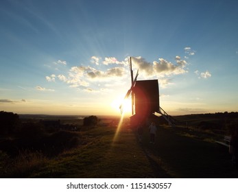 setting sun with rays through a windmill 