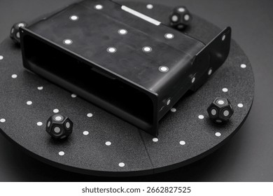 The setup includes a specialized device surrounded by cubes that aid in orienting the scanner for precise 3D scans of objects. This technology ensures optimal scanning accuracy.