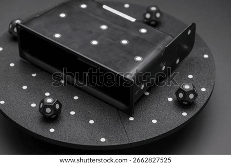 The setup includes a specialized device surrounded by cubes that aid in orienting the scanner for precise 3D scans of objects. This technology ensures optimal scanning accuracy.