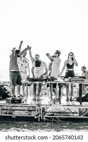 SEVAN, ARMENIA - Sep 03, 2021: A Monochrome Shot Of A Group Of Friends Partying On A Small Concert Stage At The Beach In Lake Sevan