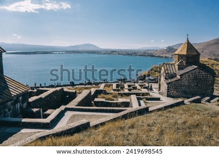Sevanavank monastery against Lake Sevan and mountains on a sunny day in Armenia.