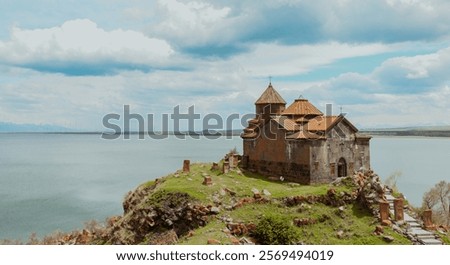 Sevanavank Monastery overlooks Lake Sevan, showcasing stunning architecture amidst serene natural beauty with clouds above.